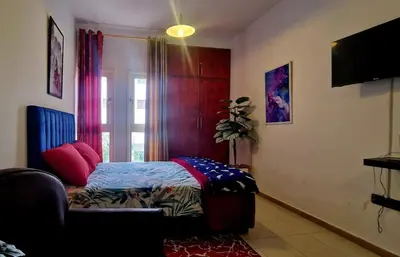 a bedroom with a bed and a window and a tv at Parisien Studio in Rabat