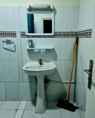a bathroom with a sink and a mirror and a mop at Parisien Studio in Rabat