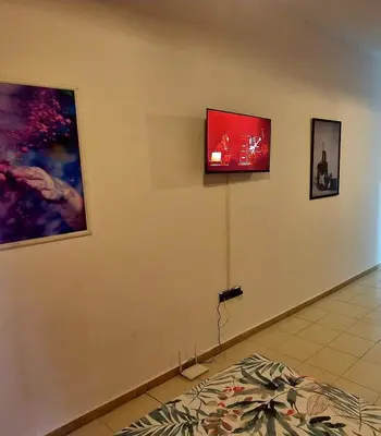 a room with three pictures on the wall and a television at Parisien Studio in Rabat