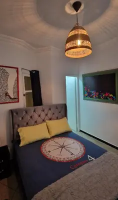 a bedroom with a bed with a clock on it at Nice studio for nice people in Rabat