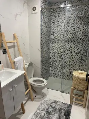 a bathroom with a shower with a toilet and a sink at Appartement pieds sur mer in Sidi Rahal