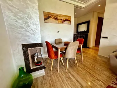 a dining room with a table and chairs and a fireplace at Ocean side - Prestige & Douceur familliale in Casablanca