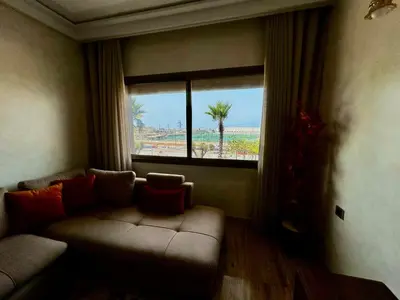 a living room with a couch and a large window at Ocean side - Prestige & Douceur familliale in Casablanca