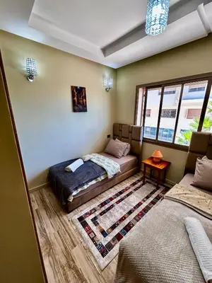 a bedroom with a bed and a couch and a window at Ocean side - Prestige & Douceur familliale in Casablanca