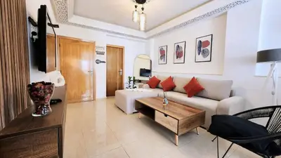 a living room with a couch and a table at Cosy and central condo with terace steps to shore in Rabat
