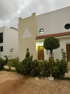 a white house with a tree in front of it at Maison ensoleillée à Skhirat, Piscine & Parking in Skhirat
