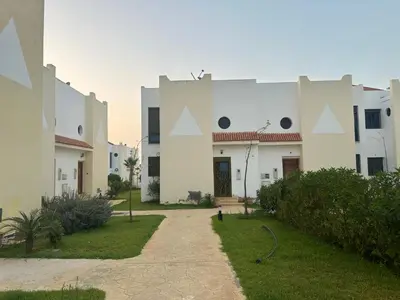 a large white building with a pathway in front of it at Maison ensoleillée à Skhirat, Piscine & Parking in Skhirat