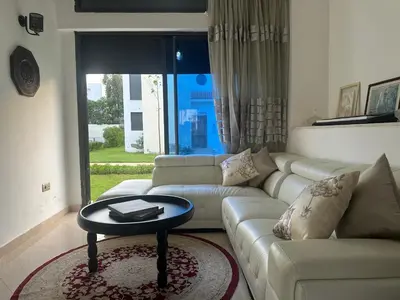 a living room with a couch and a table at Maison ensoleillée à Skhirat, Piscine & Parking in Skhirat