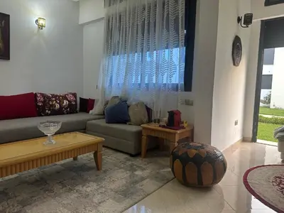 a living room with a couch and a table at Maison ensoleillée à Skhirat, Piscine & Parking in Skhirat