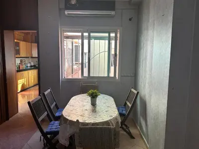 a dining room with a table with chairs and a window at Appartement A Darbouazza Tamaris 5min accès a la plage in Tamaris