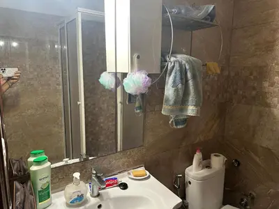 a bathroom with a sink and a toilet and a mirror at Appartement A Darbouazza Tamaris 5min accès a la plage in Tamaris