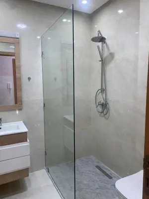a glass shower in a bathroom with a sink at Appartement neuf avec piscine in Bouznika