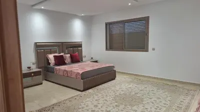 a bedroom with a bed and a window and a rug at Chambres au sein d'une villa in Rabat
