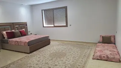 a bedroom with two beds and a window and a rug at Chambres au sein d'une villa in Rabat