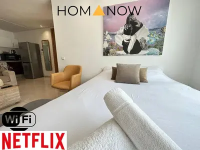 a bedroom with a large bed with a painting on the wall at Calm central Flat in Agdal in Rabat