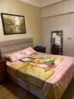 a bed with a quilt on it in a bedroom at Très bel Appartement A Darbouazza Tamaris in Tamaris