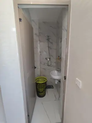 a white bathroom with a sink and a toilet at Nid d'anges in Bouznika