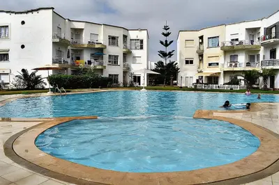 a large swimming pool in front of some buildings at Kridarek - Bel appartement avec piscine in Sidi Rahal