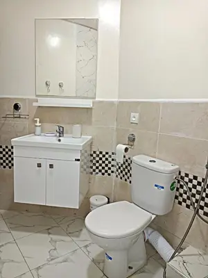 a bathroom with a white toilet and a sink at Kridarek - Bel appartement avec piscine in Sidi Rahal