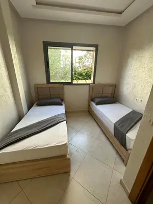two beds in a room with a window at Apartment for rent el mansoria in Mansouria