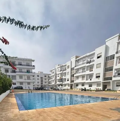 a swimming pool in front of some apartment buildings at Apartment for rent el mansoria in Mansouria