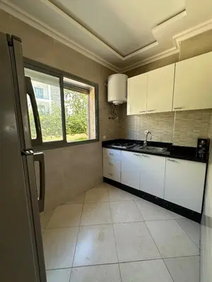 a kitchen with white cabinets and a sink and a window at Apartment for rent el mansoria in Mansouria
