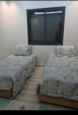 a bedroom with two beds and a window at Maison vacances à bouznika in Bouznika