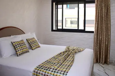 a bedroom with a white bed with pillows and a window at Holiday Harmony in Roches Noires