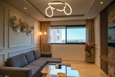 a living room with a couch and a table at 2BR Prestigia Hay Riad in Rabat