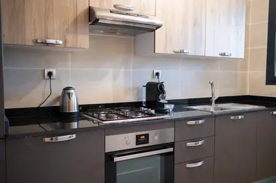 a kitchen with a stove and a sink at 2BR Prestigia Hay Riad in Rabat