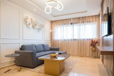 a living room with a blue couch and a table at 2BR Prestigia Hay Riad in Rabat