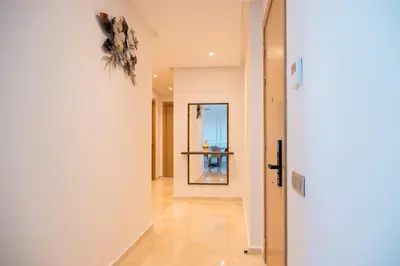 a hallway with a white wall and a mirror at 2BR Prestigia Hay Riad in Rabat