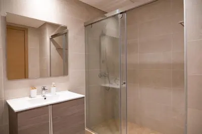 a bathroom with a glass shower and a sink at 2BR Prestigia Hay Riad in Rabat