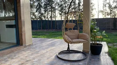 a wicker chair sitting on a patio at Dream villa with a pool