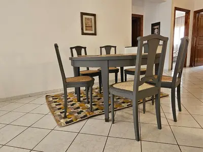 a dining room with a table and chairs on a tiled floor at Maarif Central Stay in Maarif