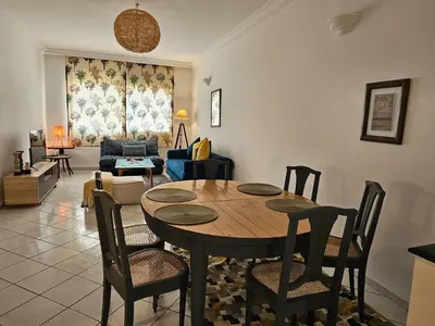 a living room with a wooden table and chairs at Maarif Central Stay in Maarif