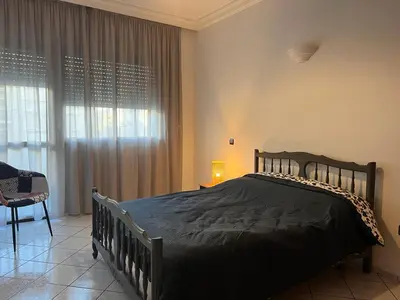 a bedroom with a bed and a chair and a window at Maarif Central Stay in Maarif