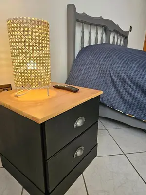a black dresser with a remote control on it next to a bed at Maarif Central Stay in Maarif