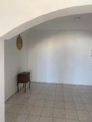 an empty room with a table and a white wall at Happy hostel in Casablanca