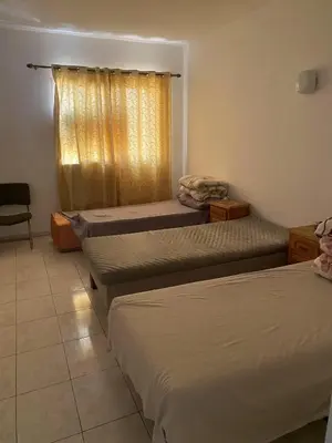 a room with three beds and a window at Happy hostel in Casablanca