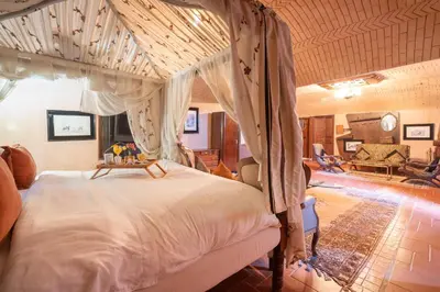 a bedroom with a canopy bed and a living room at Lakala Complexe Touristique in O Ben Slimane