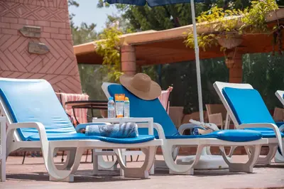 a group of chairs and an umbrella on a patio at Lakala Complexe Touristique in O Ben Slimane