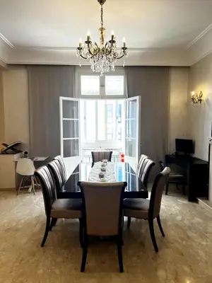 a dining room with a table and chairs and a chandelier at Dar EL BAHIA - Spacious flat with large Terrace in Casablanca