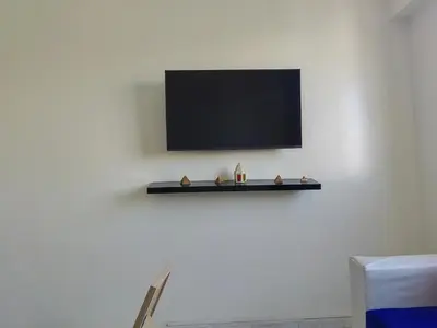 a tv on a white wall with a shelf at Mydar ocean in Rabat