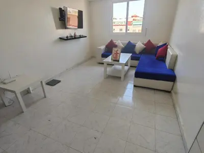 a living room with a blue couch and a table at Mydar ocean in Rabat