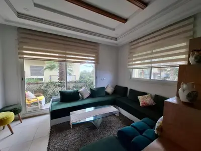 a living room with a green couch and a table at Appart Coquette à Tamariss in Tamaris