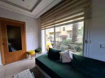 a bedroom with a green couch and a large window at Appart Coquette à Tamariss in Tamaris