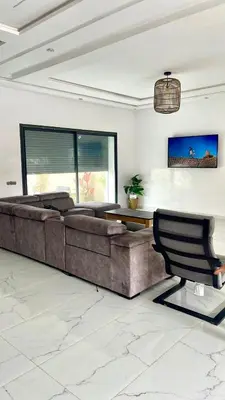 a living room with a couch and a table at Spacieuse villa oued cherrat bouznika in Bouznika
