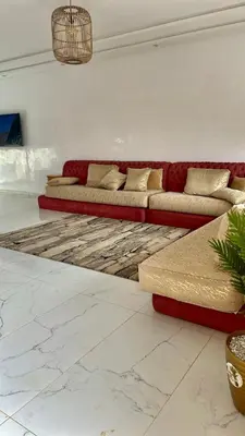 a living room with two red couches and a rug at Spacieuse villa oued cherrat bouznika in Bouznika