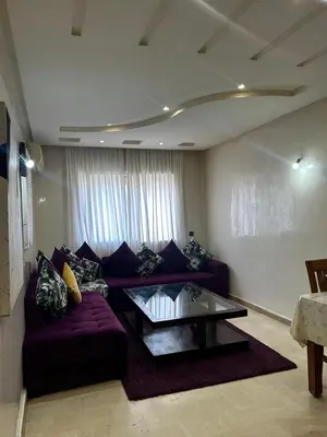 a living room with a purple couch and a glass table at Modern Studio by the Beach of Casablanca Night Stay in Casablanca
